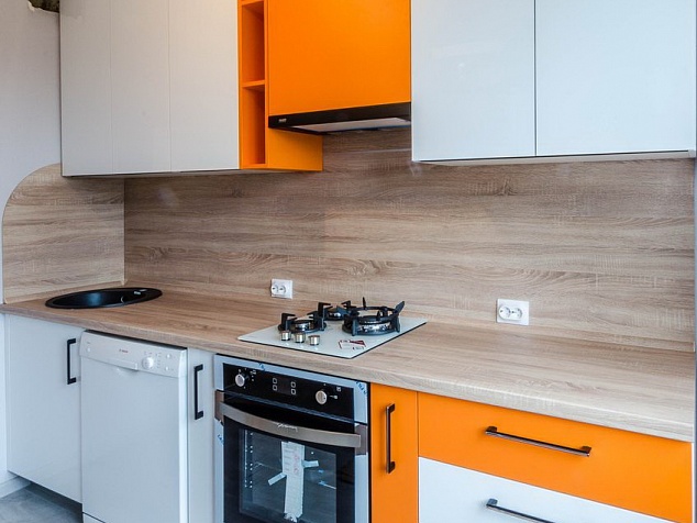 Белая линейная кухня с оранжевой отделкой, фартук и столешница под дерево