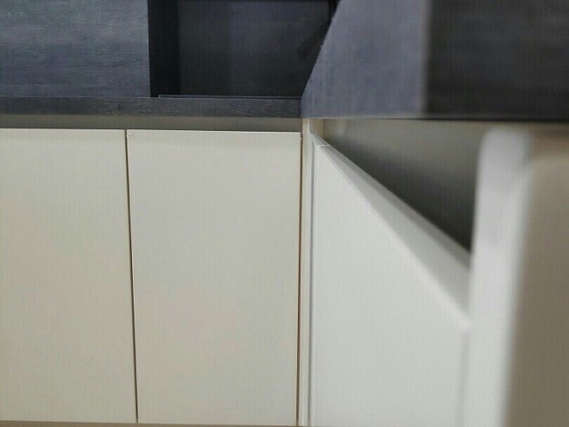 Белая кухня со столом и фартуком темный бетон в современном стиле